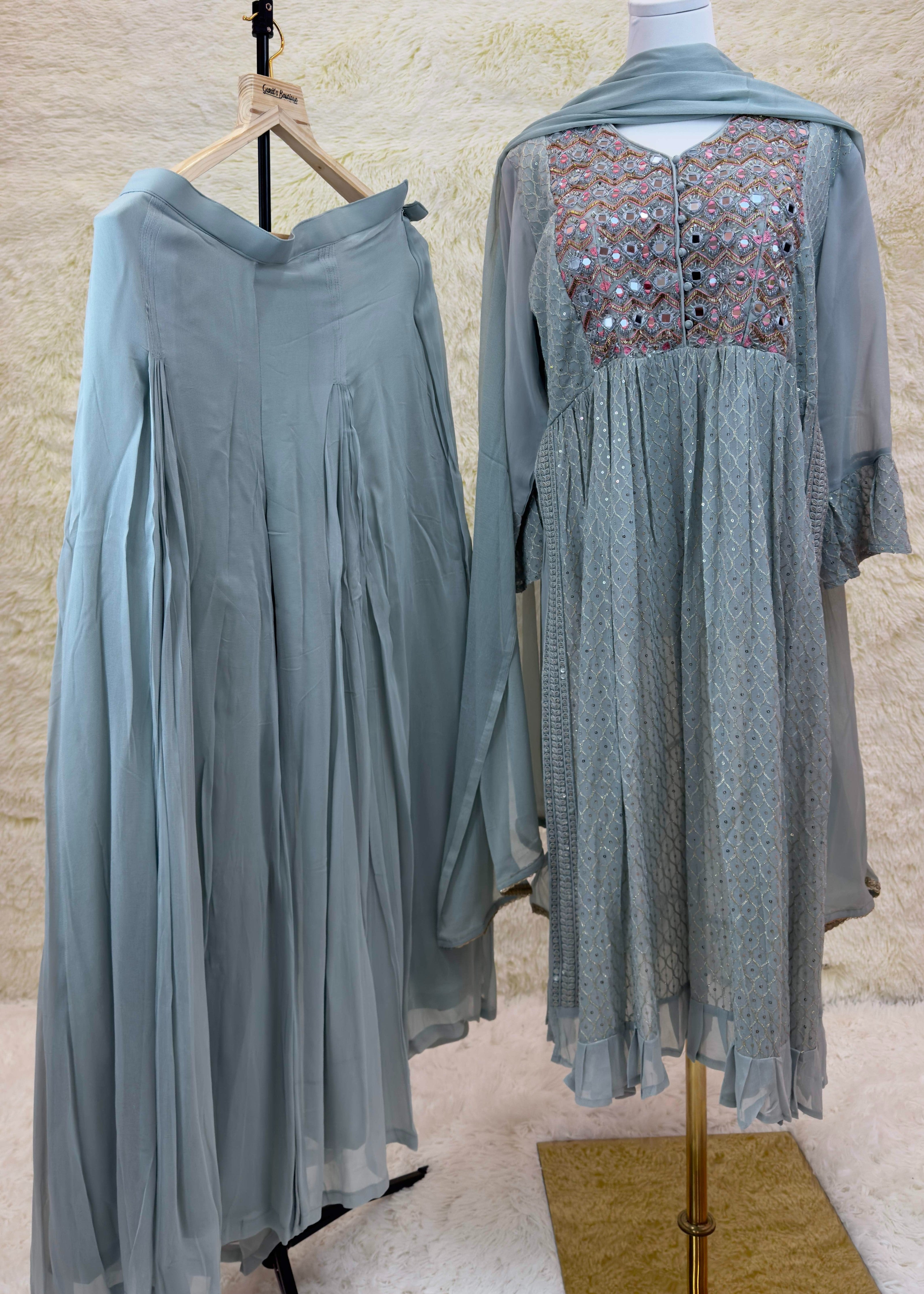 Sage ethnic ensemble with embroidered bodice and flared skirt, featuring mirror embellishments and a matching dupatta.